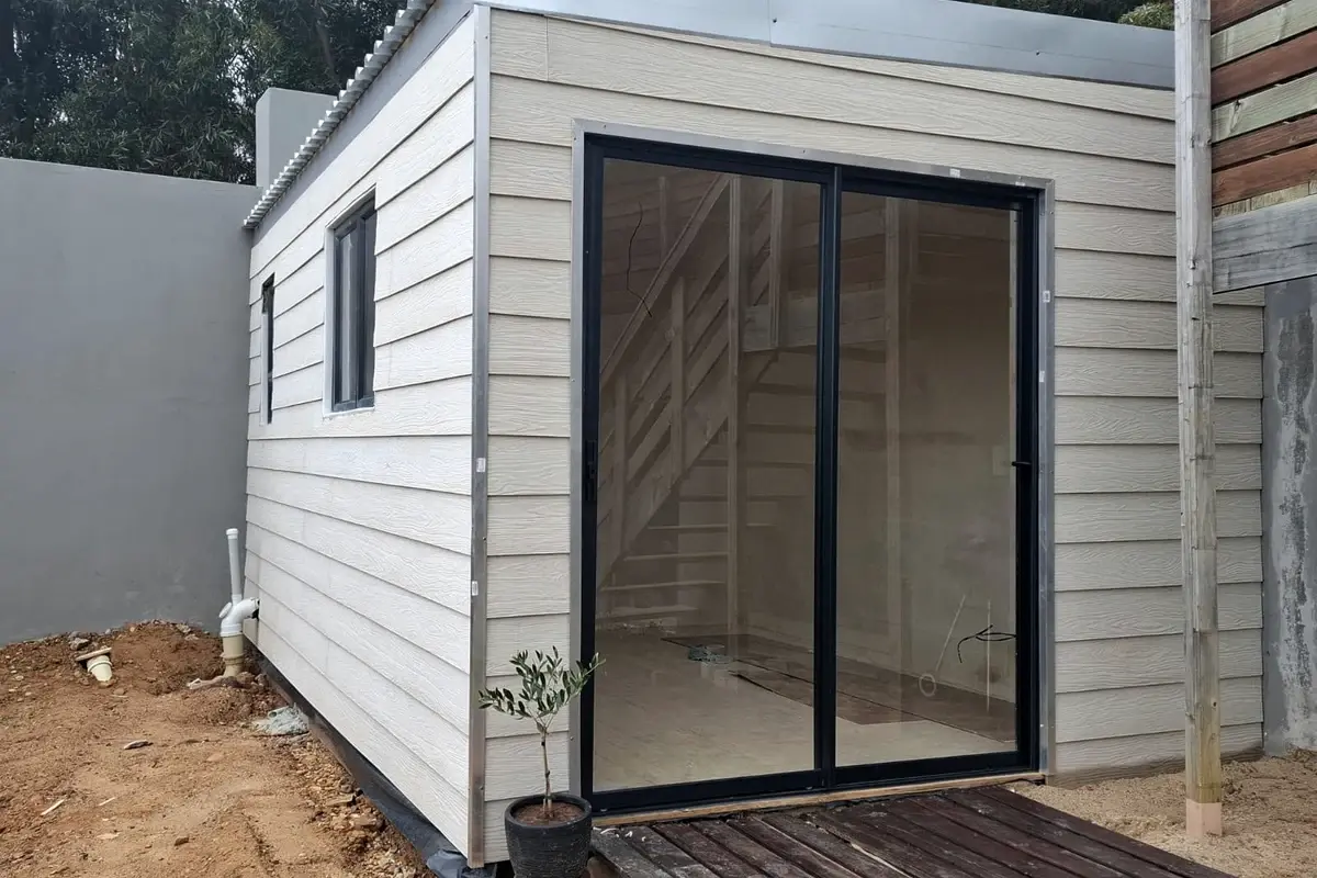 Newly built granny flat with cladding and sliding doors onto a wooden deck