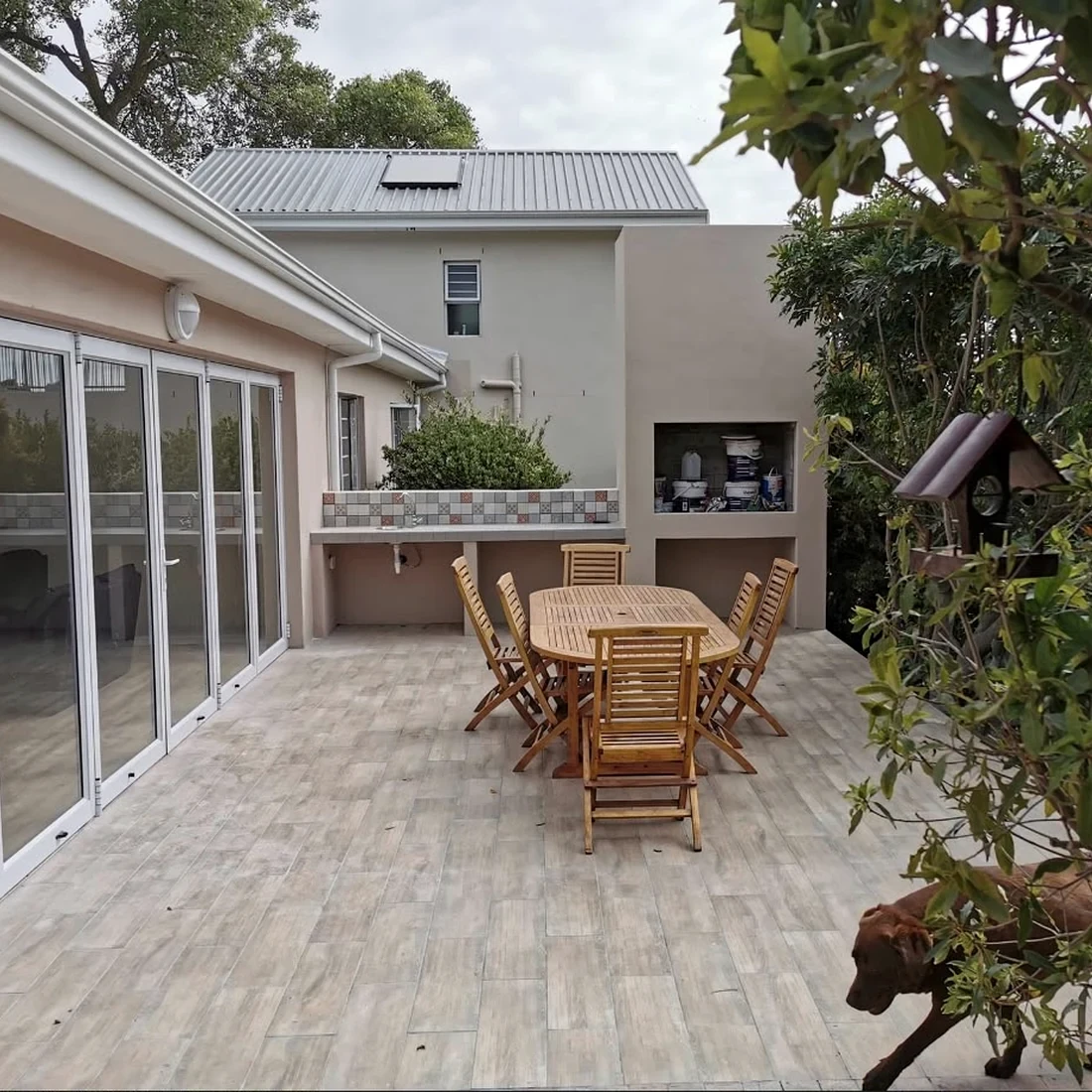 Finished patio extension with tiled floor, folding doors and a built-in braai