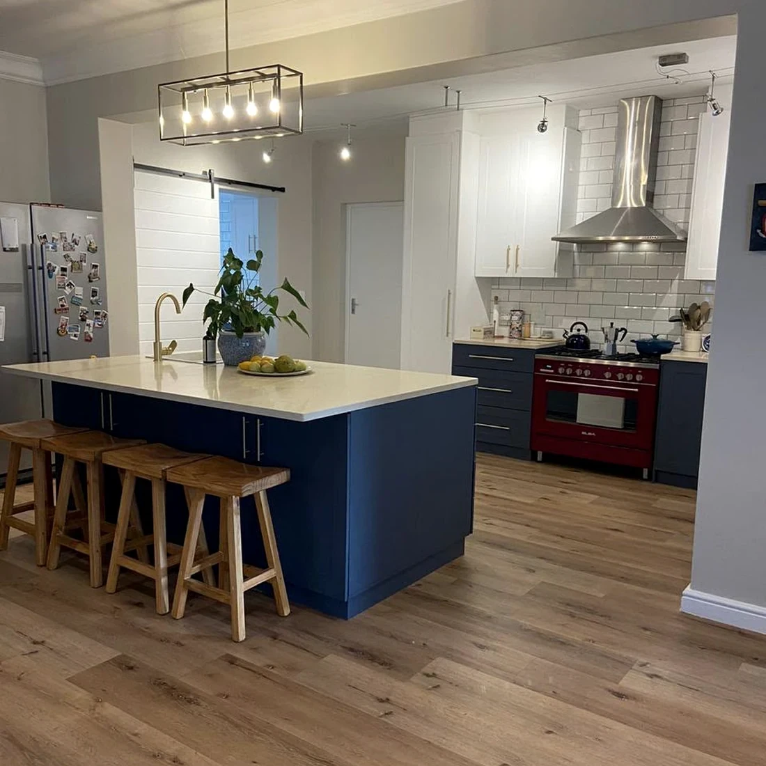 Completed kitchen renovation with a navy island, wooden floors and new cabinetry