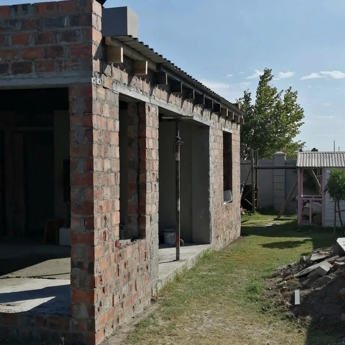 A new house going up on a Cape Town plot, brickwork complete and the roof timbers and sheeting being fitted
